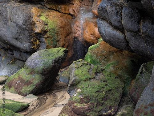 Waterfall with multicolored stones on the beach of Castro Urdiales in in the north of Spain