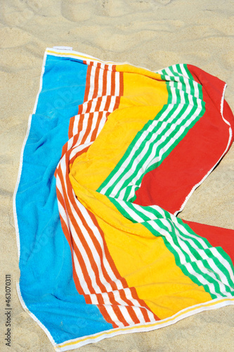 Colorful beach towel on beach sand.