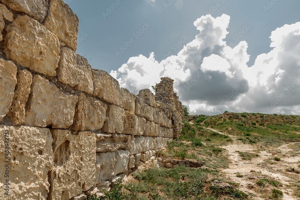 Ruins of an ancient fortress. An old wall of large stones. The remains of a former civilization.