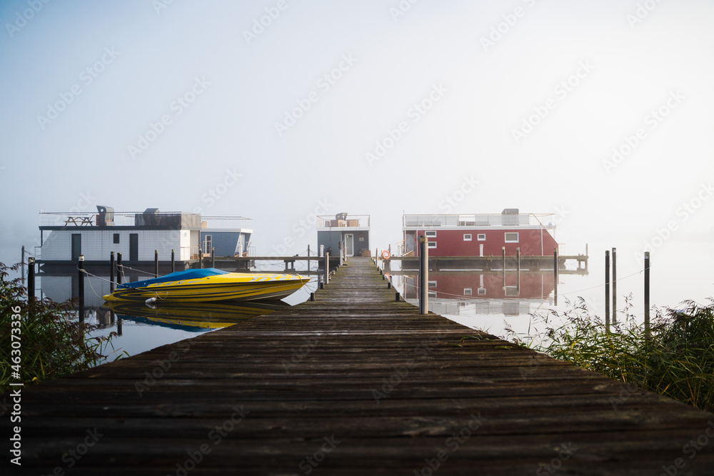 Fototapeta premium Steg mit Hausbooten im Nebel am Morgen in Schleswig