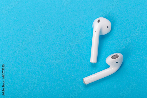 Modern wireless bluetooth headphones with charging case on a blue background. The concept of modern technology, gadgets. Modern wireless bluetooth headphones with charging case on a blue background. 