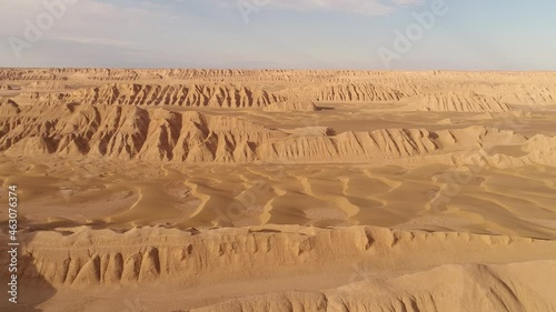 pan shot from the formation of sandstones in dasht e lut desert at the morning with cloudy sky and small sand dunes, aerial shot the formation of kalut in shahdad desert, iran photo