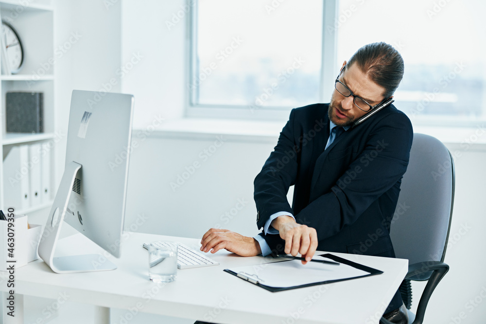 The man in a suit with glasses self-confidence work computer The man in a suit with glasses self-confidence work computer