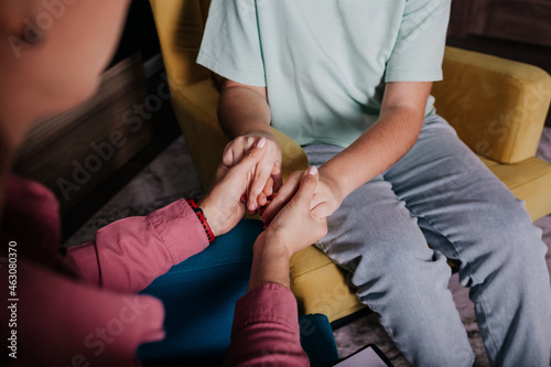 close-up of a woman's clasped hands and a child's hands