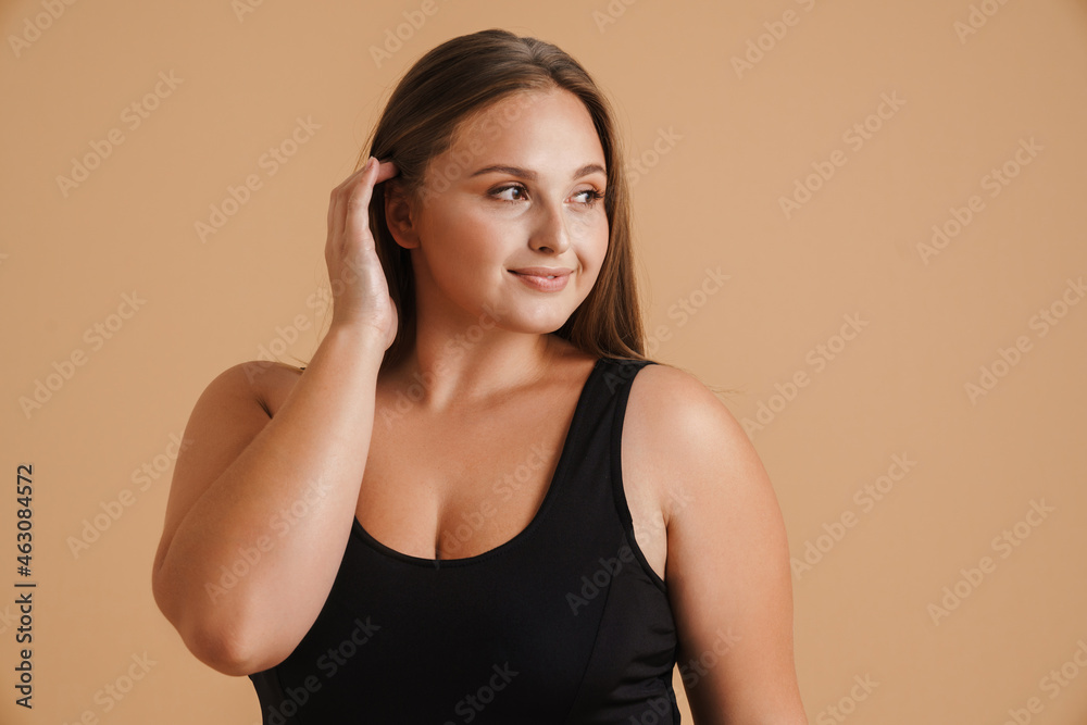 Young woman wearing swimsuit smiling and looking aside Young woman wearing swimsuit smiling and looking aside
