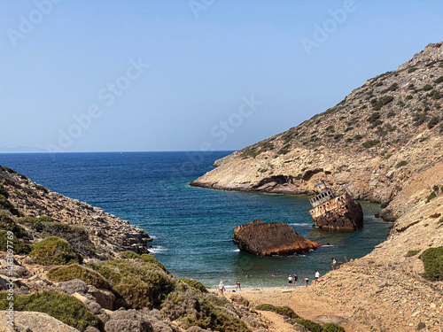 People on the beach visiting Shipwreck Olympia boat in Amorgos island during summer holidays, at the coastal rocky area, , Cyclades, Greece. Travel background