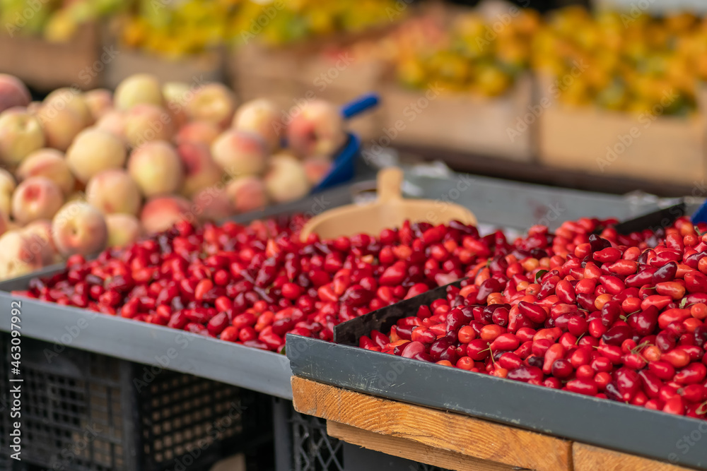 Close-up of the stalls with barberry in the market, blurred fruits in the background
