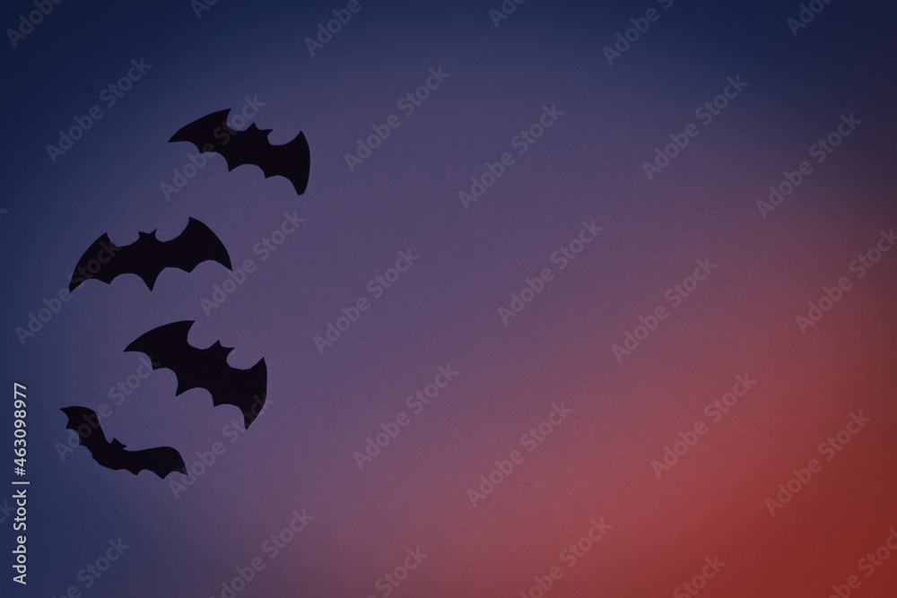 Little black toys bats on a dark blue background. Halloween concept