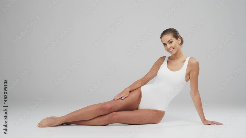 Young, beautiful, fit and natural blond woman in white swimsuit. Epilation, skin care, cellulite removal, and weight loss concepts. Young, beautiful, fit and natural blond woman in white swimsuit. Epilation, skin care, cellulite removal, and weight loss concepts.
