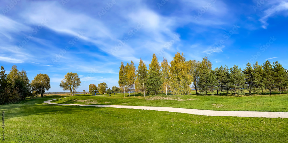 Sunny autumn landscape with beautiful meadow and small lake on the banks of Kisezers in Riga, Latvia.	