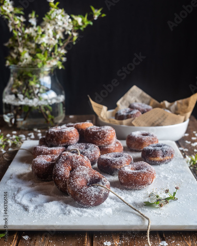 Fritters in sugar powder on table photo
