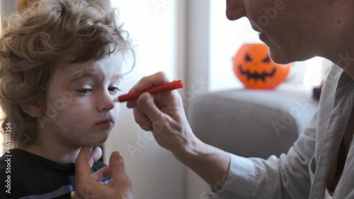 Close-up of Mother painting her son on halloween holiday
