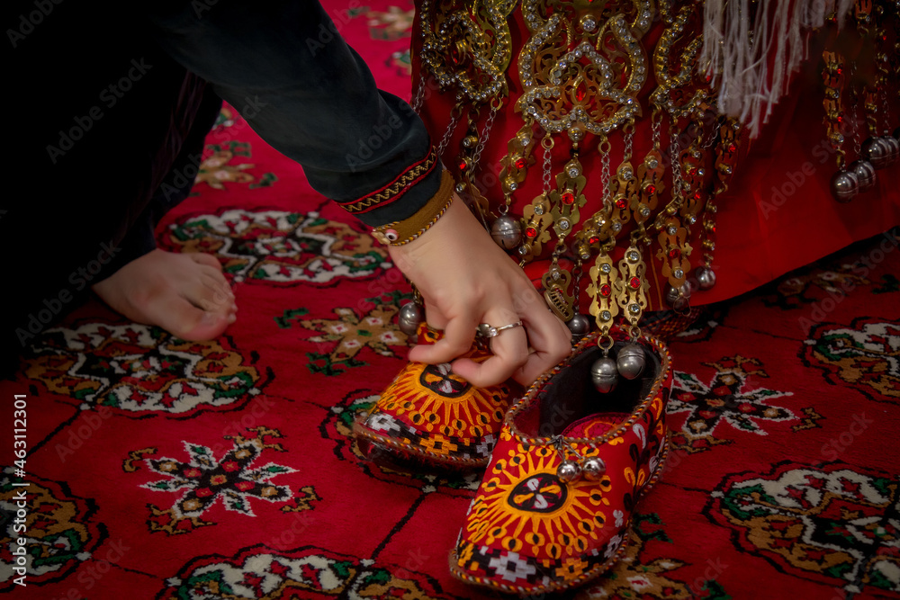 girl in national dress and national decoration puts on shoes