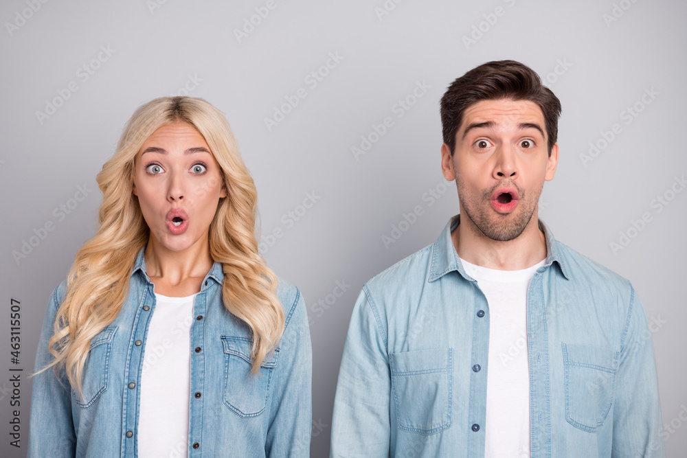 Photo of young couple amazed shocked surprised fake novelty news information isolated over grey color background - obrazy, fototapety, plakaty 