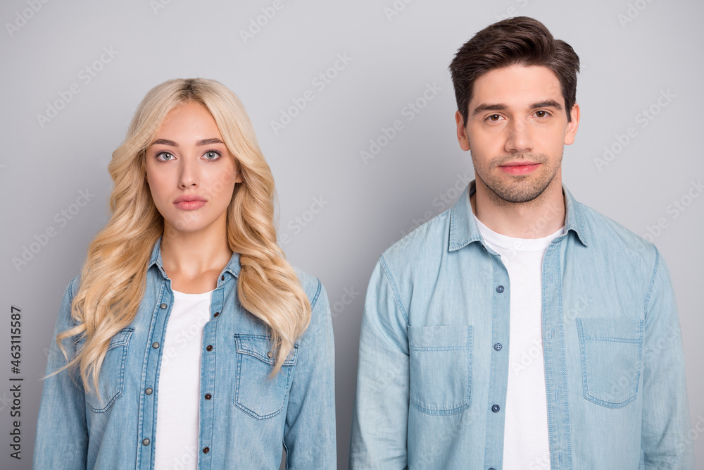 Photo of two young business people serious confident wear jeans shirt isolated over grey color background Photo of two young business people serious confident wear jeans shirt isolated over grey color background