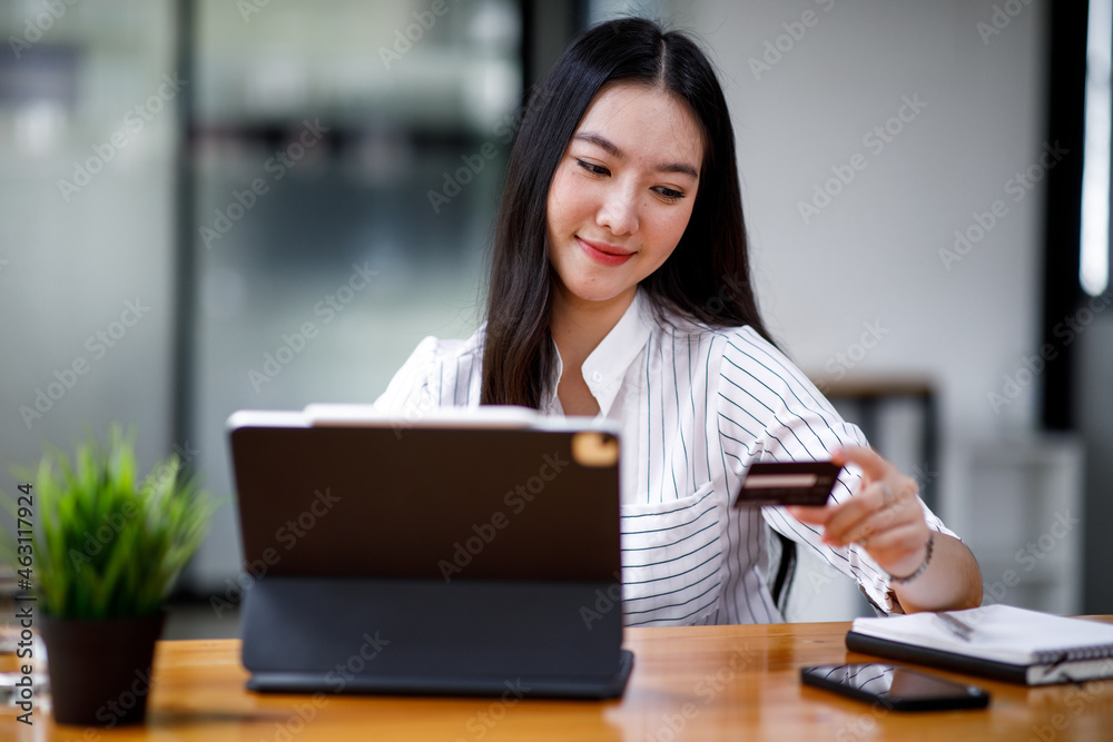 Young Asian women hand using a credit card and tablet computer payments for online shopping, Online shopping, digital banking, E-commerce concept. Young Asian women hand using a credit card and tablet computer payments for online shopping, Online shopping, digital banking, E-commerce concept.