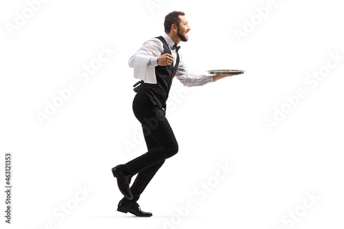 Full length profile shot of a waiter running with a silver tray photo