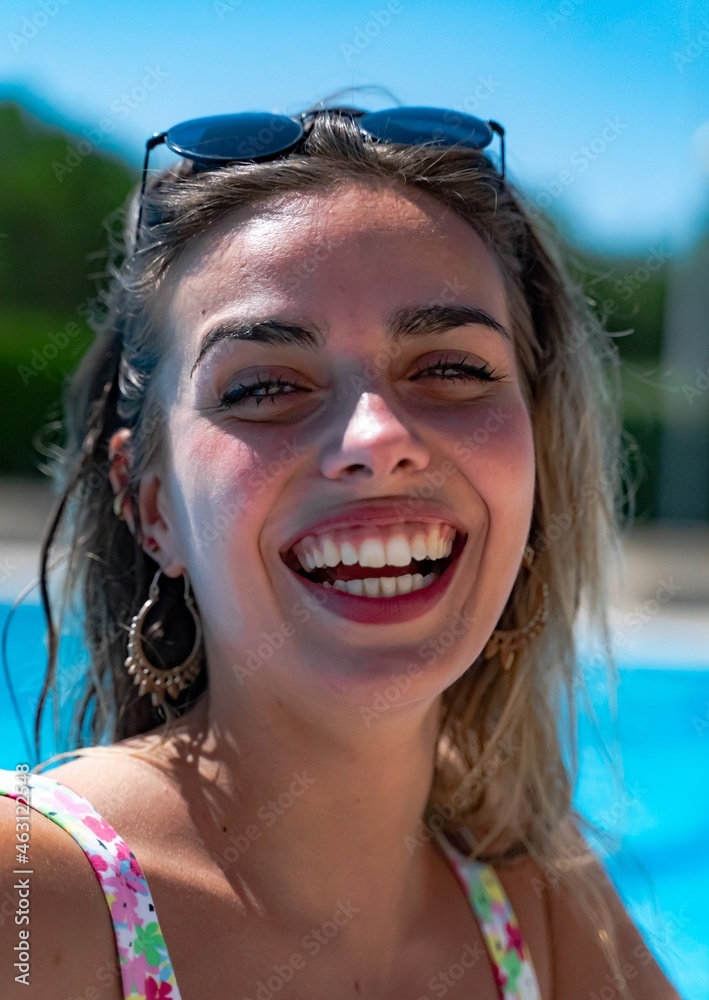 Smiling blonde girl on vacation in the pool