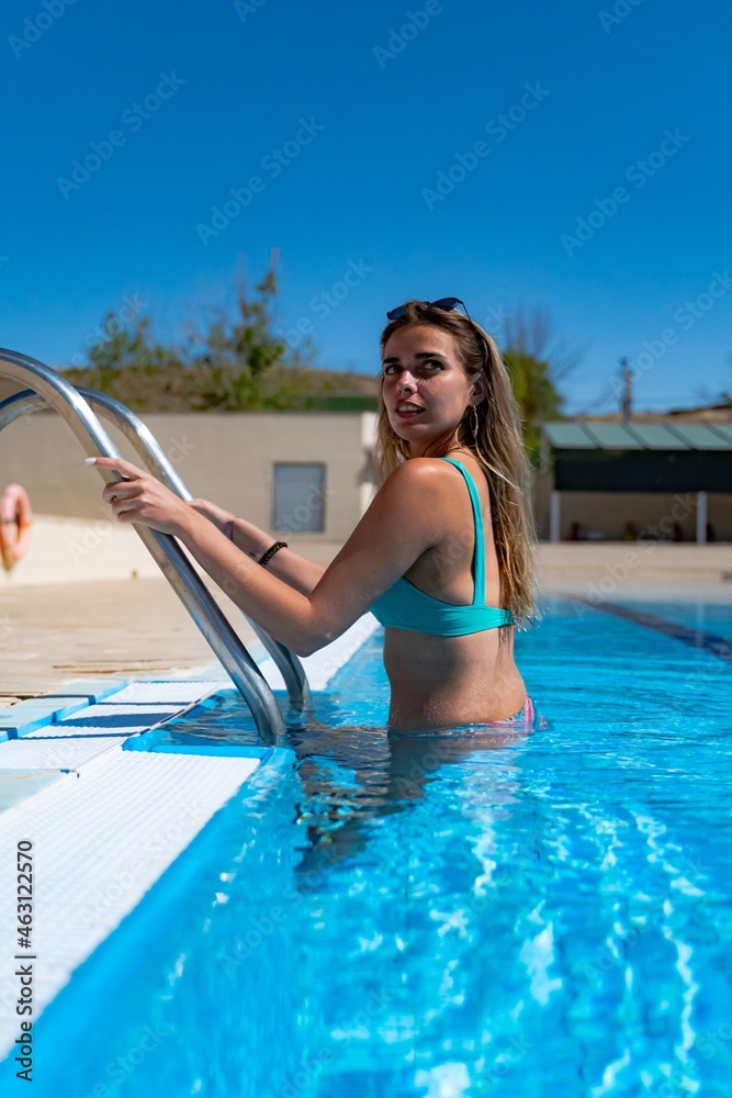 Young girl entering the pool slowly