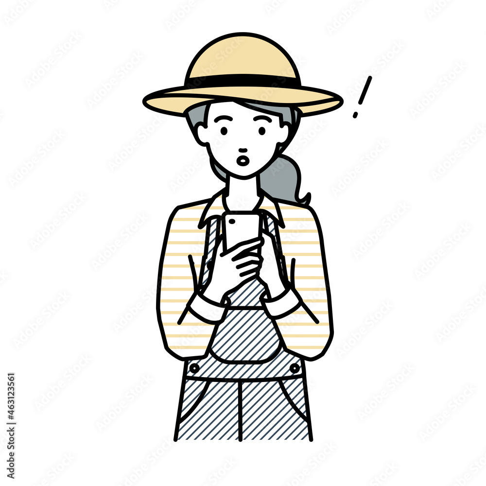 立ってスマートフォンを操作して何かに気づいて驚いた農家の女性 立ってスマートフォンを操作して何かに気づいて驚いた農家の女性