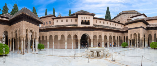 Full panoramic exterior view at the Patio at the Lions  twelve marble lions fountain on Palace of the Lions or Harem  Alhambra citadel  tourist people visiting