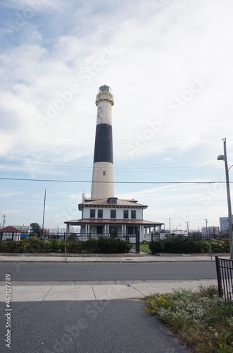 Black and White Horizontal Striped Lighthouse Against Blue Sky Full View