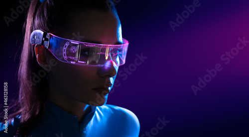 Concept of future technology or entertainment system, virtual reality. Female portrait lit by HUD interface © konradbak