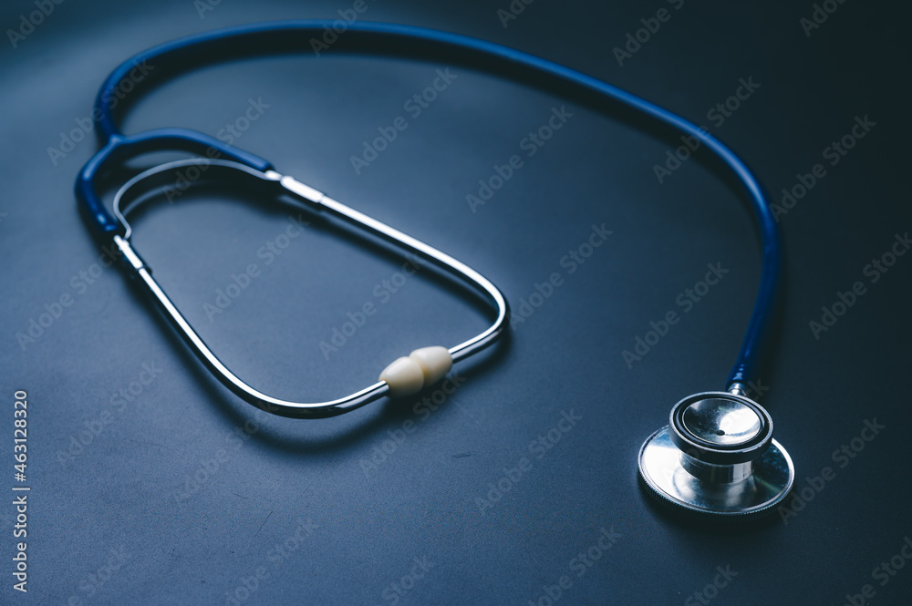 Closeup of a stethoscope isolated against blue table Closeup of a stethoscope isolated against blue table