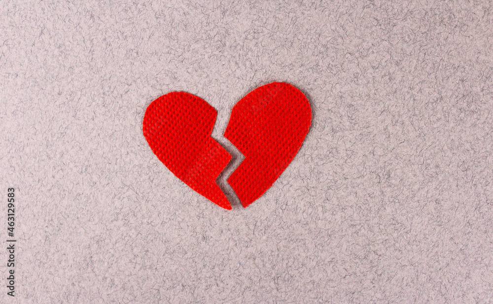 Obraz premium Broken red heart on a gray background