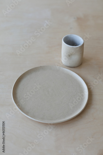 ceramic cup and plates on a wooden table top view. minimalist set of handmade ceramic tableware and pottery