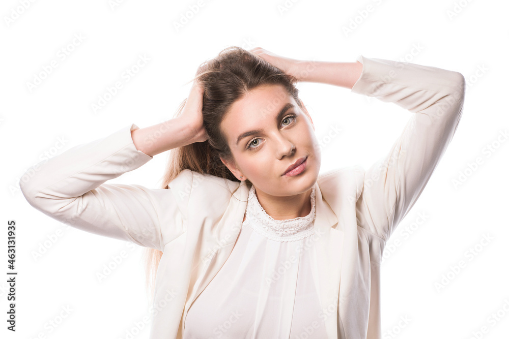 Woman straightens hair. Studio Portrait of Young Woman in a White Suit. Beauty Isolate Image Hairstyle Horizontal. Brown-haired Long Hair Female Looking Straight. Woman straightens hair. Studio Portrait of Young Woman in a White Suit. Beauty Isolate Image Hairstyle Horizontal. Brown-haired Long Hair Female Looking Straight.