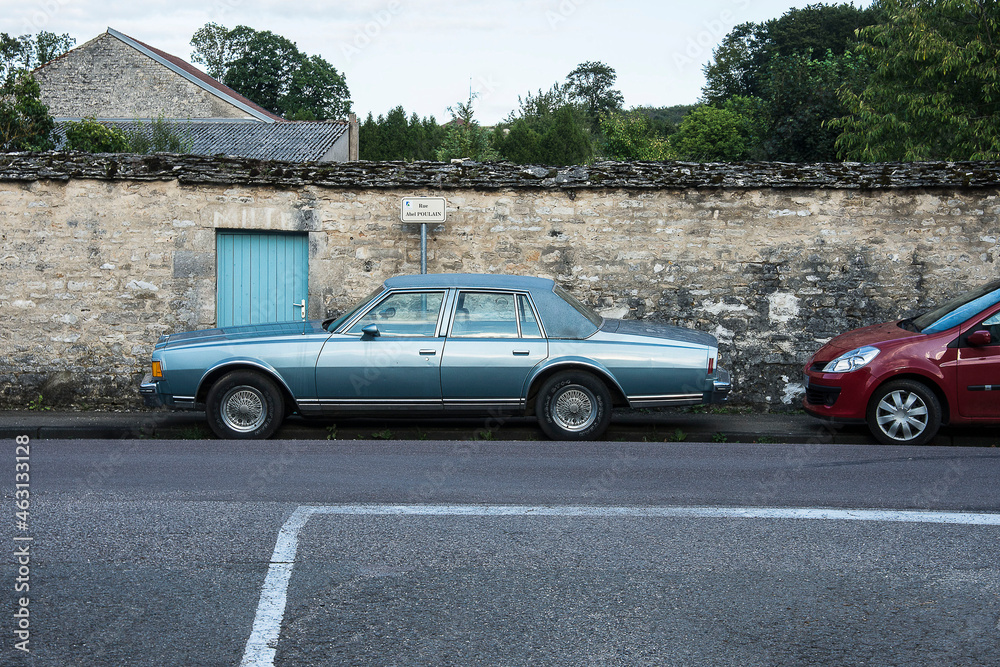 old classic car in front of a stone wall in the French village of Arc en Barrois in Champagne Ardenne