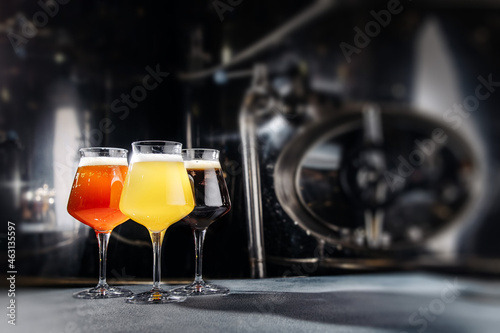 Three beer glasses at the dark background.