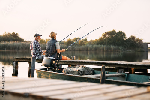Back view of senior man and his son enjoy in freshwater fishing.