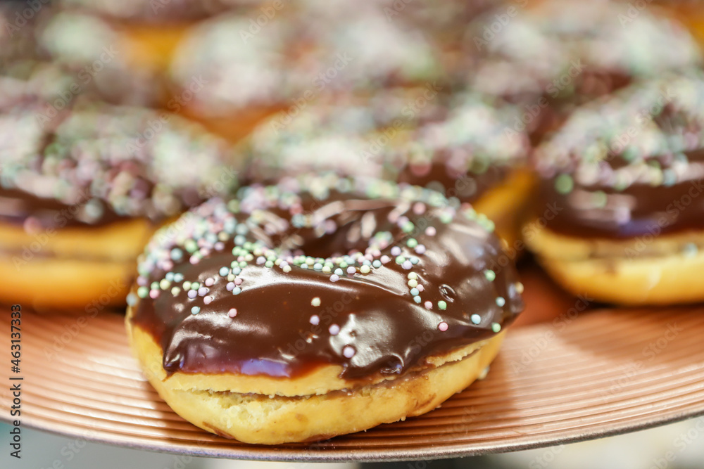 Chocolate filled donuts in a brown platter and on top of it small, colorful candy confetti
Chocolate filled donuts in a brown platter and on top of it small, colorful candy confetti