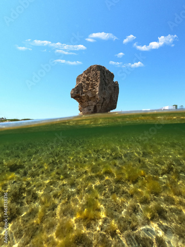 Underwater split photo of iconic rock formations in Pouria beach an old stone factory, Skyros island, Sporades, Greece photo