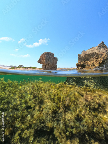 Underwater split photo of iconic rock formations in Pouria beach an old stone factory, Skyros island, Sporades, Greece photo