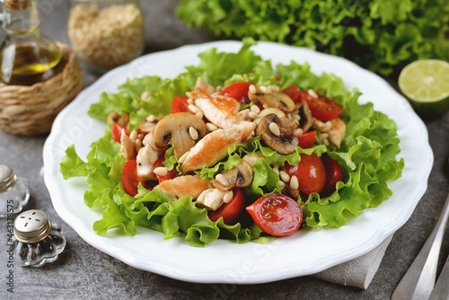 Salad with chicken breast, cherry tomatoes, mushrooms, lettuce and pine nuts.