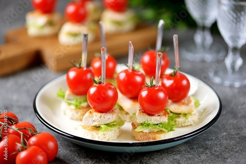 Canapes with croutons, lettuce, fried chicken breast, parmesan cheese and cherry tomato.