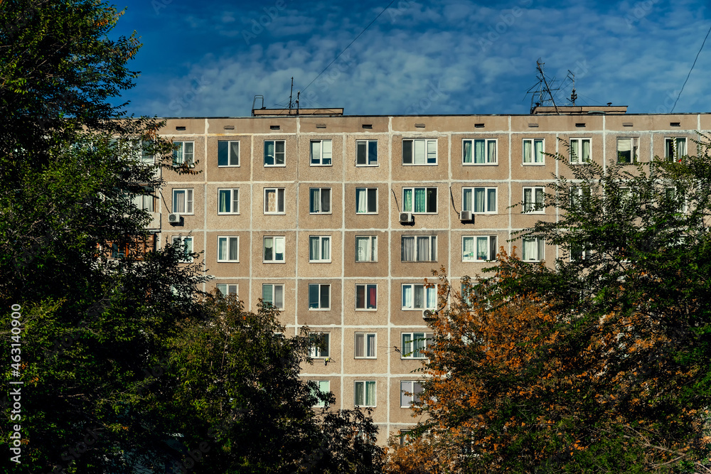 Windows and balconies of the residential building. Old urban obsolete facade of panel house. The windows of an ordinary soviet building.