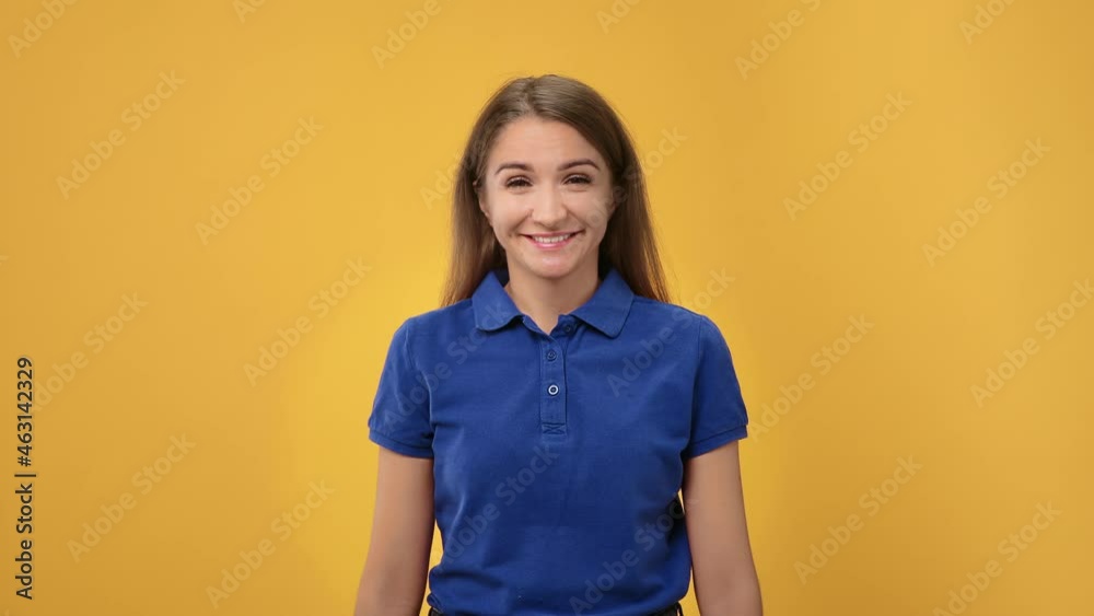 Portrait of cheerful young woman smiling with gesture come here asking joining to her posing isolated on orange studio