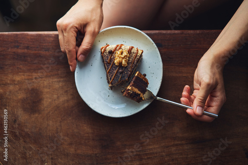 Anonymous female person enjoying delicious chocolate dessert in cafe photo