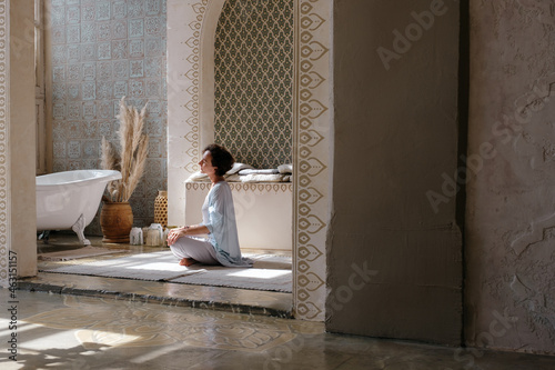 Woman meditating in oriental bathroom photo