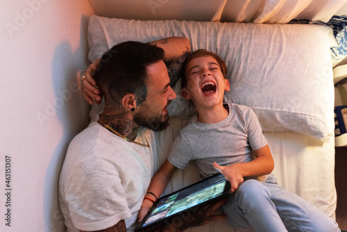 Father and son laughing at video