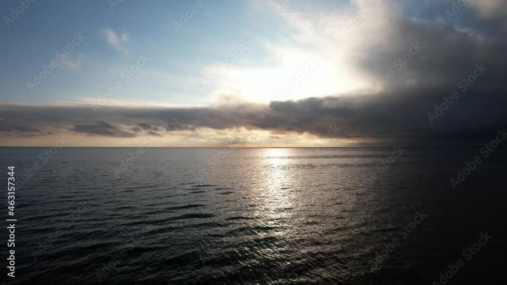 Take off over the sea. aerial view of powerful clouds over the sea at sunset, the sun's rays pass through the clouds and are reflected in the water. Take off over the sea. aerial view of powerful clouds over the sea at sunset, the sun's rays pass through the clouds and are reflected in the water.