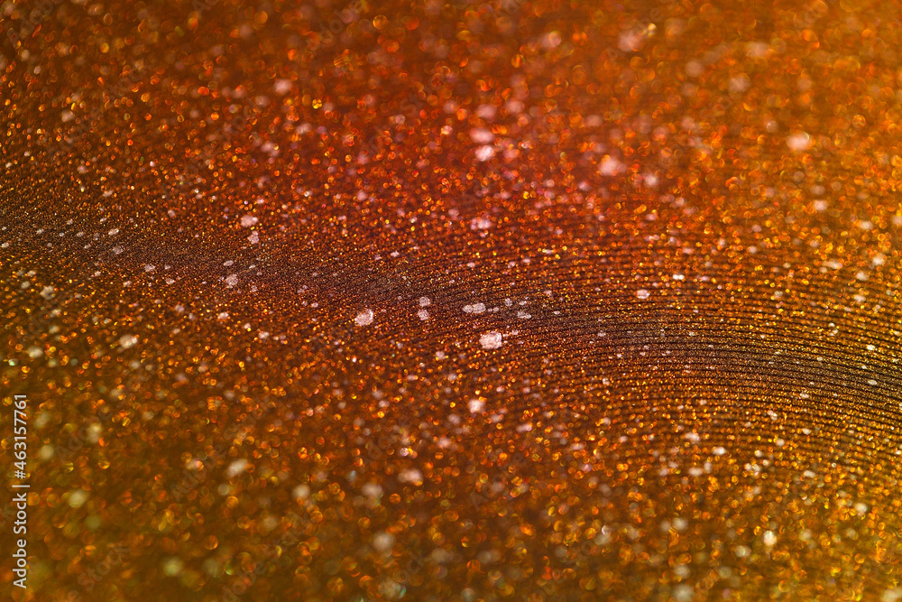 Shimmering orange sandy background with wavy texture and blur. Macro image of a metallic shiny surface