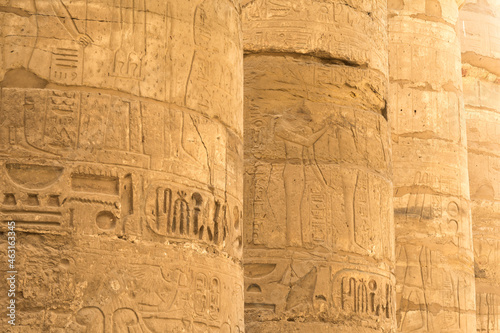 Ancient columns in a row with carved egyptian hieroglyphics 