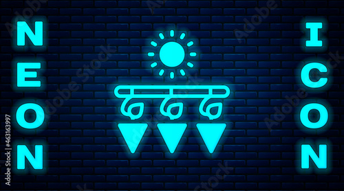 Glowing neon Drying grapes icon isolated on brick wall background. Dried grapes. Vector