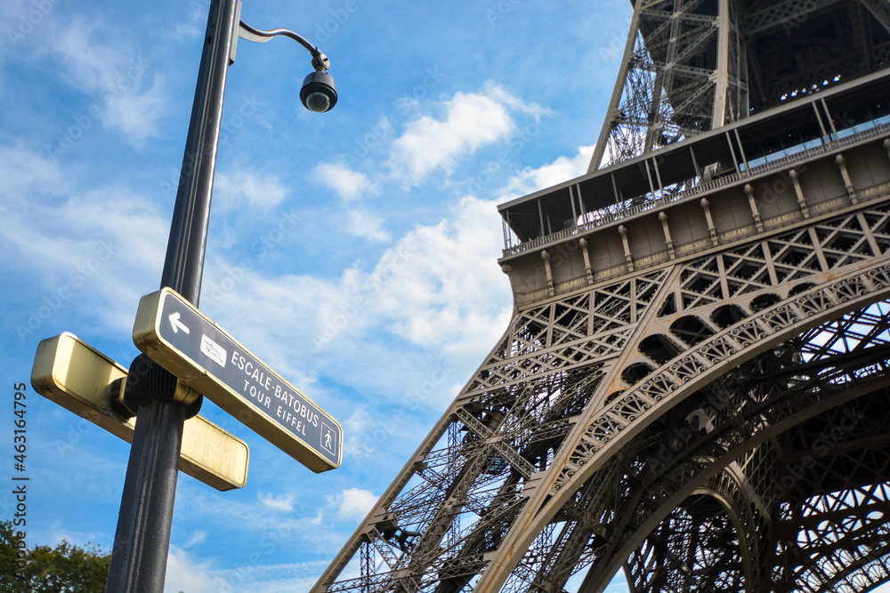 A sunny day in Paris France with a street sign for the Escale Batobus and the Tour Eiffel and the Eiffel Tower in the background