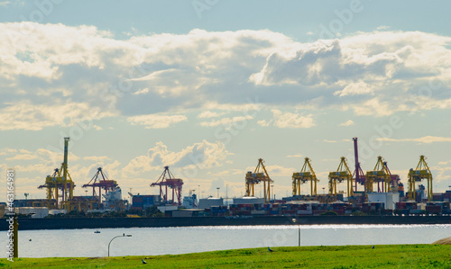 Slika na platnu Port Botany  with shipping containers and container cranes against a cloudy sky